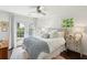 Bright bedroom with a ceiling fan, white bedding, and a private door leading to a backyard deck at 115 Peachtree St, Charleston, SC 29403