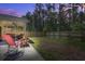 Backyard with patio featuring outdoor seating, privacy fence and screened porch at dusk at 117 Camellia Bloom Dr, Moncks Corner, SC 29461