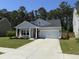 Charming single-story home featuring a two-car garage, manicured lawn, and inviting front porch at 117 Camellia Bloom Dr, Moncks Corner, SC 29461