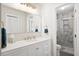 Well lit bathroom with a sink vanity, a large mirror, and an adjacent shower at 119 Savannah Round, Summerville, SC 29485