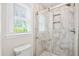 Modern bathroom with a glass shower, window, and white marble style tile throughout at 119 Savannah Round, Summerville, SC 29485