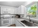 Well-lit kitchen with white cabinets, granite countertops, and stainless steel sink, offering modern convenience at 119 Savannah Round, Summerville, SC 29485