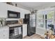 Compact kitchen featuring white cabinets and modern black appliances next to a window at 122 Brockman Way, Goose Creek, SC 29445