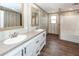 Bathroom featuring double sink vanity, framed mirrors, wood-look floors, and shower/tub combo at 1330 Whitehouse Rd, Summerville, SC 29486