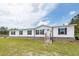 Charming single-story home featuring a white facade, black shutters, and a well-maintained lawn and landscaping at 1330 Whitehouse Rd, Summerville, SC 29486