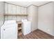 Functional laundry room with washer, dryer, shelving and wood-look floors at 1330 Whitehouse Rd, Summerville, SC 29486