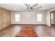 An open living space with wood-look floors, two windows, and a ceiling fan at 1330 Whitehouse Rd, Summerville, SC 29486