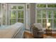 Bright bedroom with bay windows, wood floors, stylish chair and elegant bedside table at 1500 Trumpet Vine Ct, Mount Pleasant, SC 29464