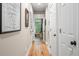Hallway with wood floors leading to a bright room, white doors, and decorative artwork at 1500 Trumpet Vine Ct, Mount Pleasant, SC 29464