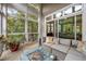 Bright sunroom with comfortable couch, stylish fire pit, potted palm, and view to trees at 1500 Trumpet Vine Ct, Mount Pleasant, SC 29464