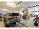 Spacious garage with modern car, wooden stairs, and ample storage and overhead lighting at 1500 Trumpet Vine Ct, Mount Pleasant, SC 29464