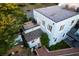 Aerial view of a light blue home, with a rooftop deck and tile roof. The house is nestled among trees and landscaping at 154 Wentworth St, Charleston, SC 29401