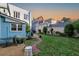 Lush backyard with manicured lawn, brick path, patio with grill, and blue two-story home at 154 Wentworth St, Charleston, SC 29401