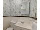 Cozy bathroom featuring a classic sink, toilet, floral wallpaper, and a framed mirror at 154 Wentworth St, Charleston, SC 29401