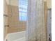 Bathroom with a tub/shower combination, neutral tiling, and a window for natural light at 154 Wentworth St, Charleston, SC 29401