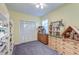 Well-lit bedroom with hardwood dressers, a closet, and a shelf displaying antique dollhouses at 154 Wentworth St, Charleston, SC 29401