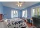 Blue bedroom with windows, quilt bedspread, desk and hardwood floors at 154 Wentworth St, Charleston, SC 29401