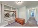 Bright laundry room with modern side-by-side washer and dryer set, ample storage, and a cedar chest at 154 Wentworth St, Charleston, SC 29401