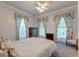 Serene bedroom featuring three windows with floral drapes, vintage dresser and a relaxing chair at 154 Wentworth St, Charleston, SC 29401