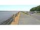 Scenic waterfront view featuring a walking path, railing, and waterfront with greenery in the background at 154 Wentworth St, Charleston, SC 29401