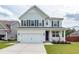 Charming two-story home with a well-manicured lawn, inviting front porch, and a two-car garage at 158 Boots Branch Rd, Summerville, SC 29485