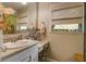 Bright bathroom with vanity, sink, mirror, chair, and two windows providing natural light at 160 High Hammock Villas, Seabrook Island, SC 29455