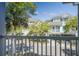 Balcony view of coastal homes surrounded by lush landscaping and a view of the street at 1637 Folly Creek Way # E-12, Charleston, SC 29412