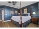 A bedroom with a four poster bed, hardwood floors, and blue walls is nicely decorated at 1637 Folly Creek Way # E-12, Charleston, SC 29412