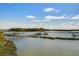 Scenic waterfront view with docks, boats, and lush green surroundings under a bright blue sky at 1637 Folly Creek Way # E-12, Charleston, SC 29412