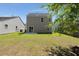 Backyard with green grass, and a gray two story home with sliding glass doors to a patio at 168 Keaton Brook Dr, Summerville, SC 29485