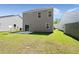 Backyard with green grass, and a gray two story home with sliding glass doors to a patio at 168 Keaton Brook Dr, Summerville, SC 29485