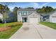 Charming two-story home with a well-manicured lawn, attached garage, and a bright blue front door at 168 Keaton Brook Dr, Summerville, SC 29485
