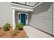 Close-up of a vibrant blue front door with sidelights and white trim, framed by lush landscaping at 168 Keaton Brook Dr, Summerville, SC 29485