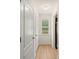 Hallway with wood-look flooring, white doors, and natural light from the window at 168 Keaton Brook Dr, Summerville, SC 29485