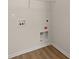 Close up of laundry hook ups in laundry room with hardwood flooring and white baseboards at 168 Keaton Brook Dr, Summerville, SC 29485