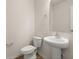 Well-lit powder room with pedestal sink, toilet and decorative mirror at 168 Keaton Brook Dr, Summerville, SC 29485
