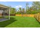 Manicured backyard featuring green grass, a wood fence, and a screened porch at 1728 Refuge Dr, Ladson, SC 29456