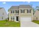 Charming two-story home with a well-manicured lawn and attached two-car garage at 1728 Refuge Dr, Ladson, SC 29456