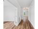 Hallway with hardwood floors, white walls, french doors and view to a bright adjacent room at 1728 Refuge Dr, Ladson, SC 29456