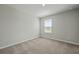 A cozy bedroom features plush carpeting, a neutral color palette, and a window offering natural light at 183 Greenwich Dr, Summerville, SC 29486