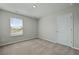 Carpeted bedroom with a window, neutral walls, and a closed white door at 183 Greenwich Dr, Summerville, SC 29486