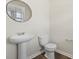 Modern powder room featuring a pedestal sink, toilet, and wood-look flooring at 183 Greenwich Dr, Summerville, SC 29486