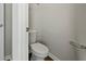 A half bathroom featuring a toilet, towel bar, and a door ajar revealing the room's interior at 183 Greenwich Dr, Summerville, SC 29486