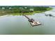Aerial showcases a long dock, boat lift, and multiple boats on the water near homes at 1905 Lone Oak Pt, Mount Pleasant, SC 29466