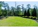 Lush backyard featuring a manicured lawn, landscaped hedges, and mature trees, offering a private and serene outdoor space at 1905 Lone Oak Pt, Mount Pleasant, SC 29466