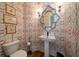 Charming powder room showcasing a decorative mirror and unique patterned wallpaper at 1905 Lone Oak Pt, Mount Pleasant, SC 29466