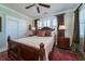 Comfortable bedroom showcasing a wooden bed frame, complemented by shuttered windows and tasteful decor, inviting relaxation at 1905 Lone Oak Pt, Mount Pleasant, SC 29466