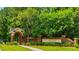 Welcoming Rivertowne Country Club entrance featuring brick pillars, stone signage, and lush landscaping at 1905 Lone Oak Pt, Mount Pleasant, SC 29466