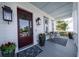 Inviting front porch with mahogany door, stylish lanterns, planters, and a cozy seating area with patterned rug at 1905 Lone Oak Pt, Mount Pleasant, SC 29466