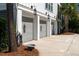 Spacious three-car garage featuring modern doors, lantern sconces, and a wide driveway, providing ample parking and curb appeal at 1905 Lone Oak Pt, Mount Pleasant, SC 29466